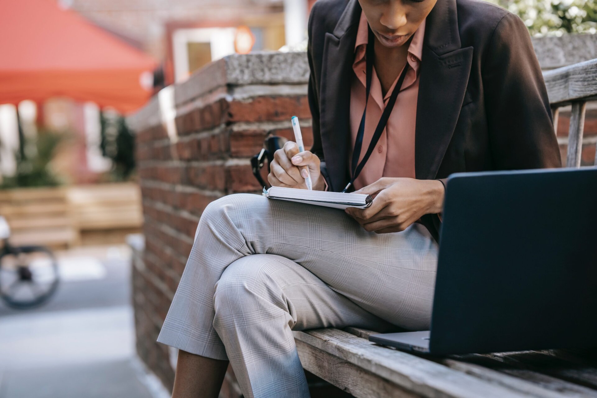 woman writing notes from laptop